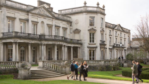 Student walking outside of Grove House at the University of Roehampton